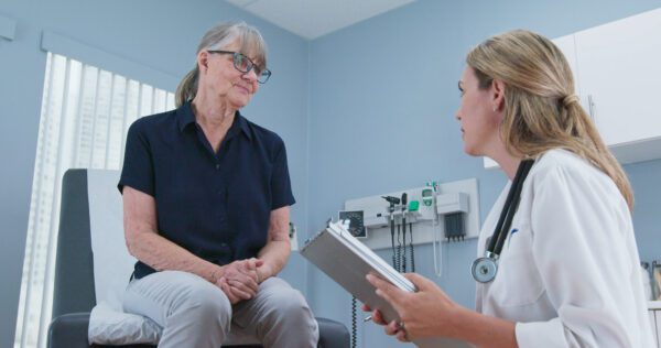 A doctor taking medical history of the older patient